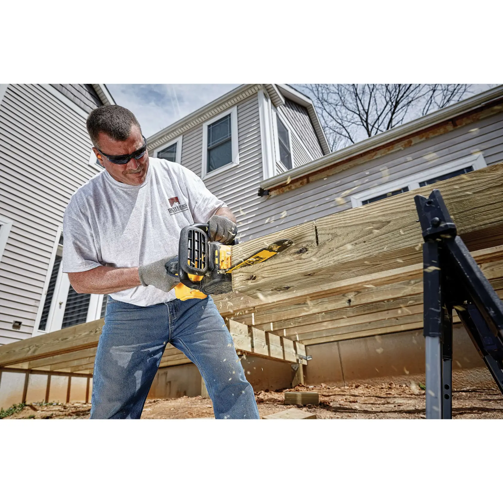 Una motosierra inalámbrica DEWALT 20V XR Brushless de color amarillo y negro con asa lateral y protector de seguridad, mostrada sobre un fondo blanco.