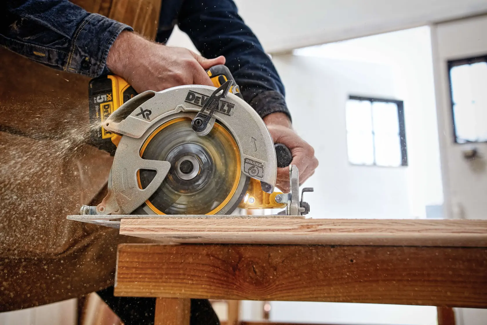 Sierra circular DEWALT cortando madera en una mesa de trabajo con aserrín en taller.