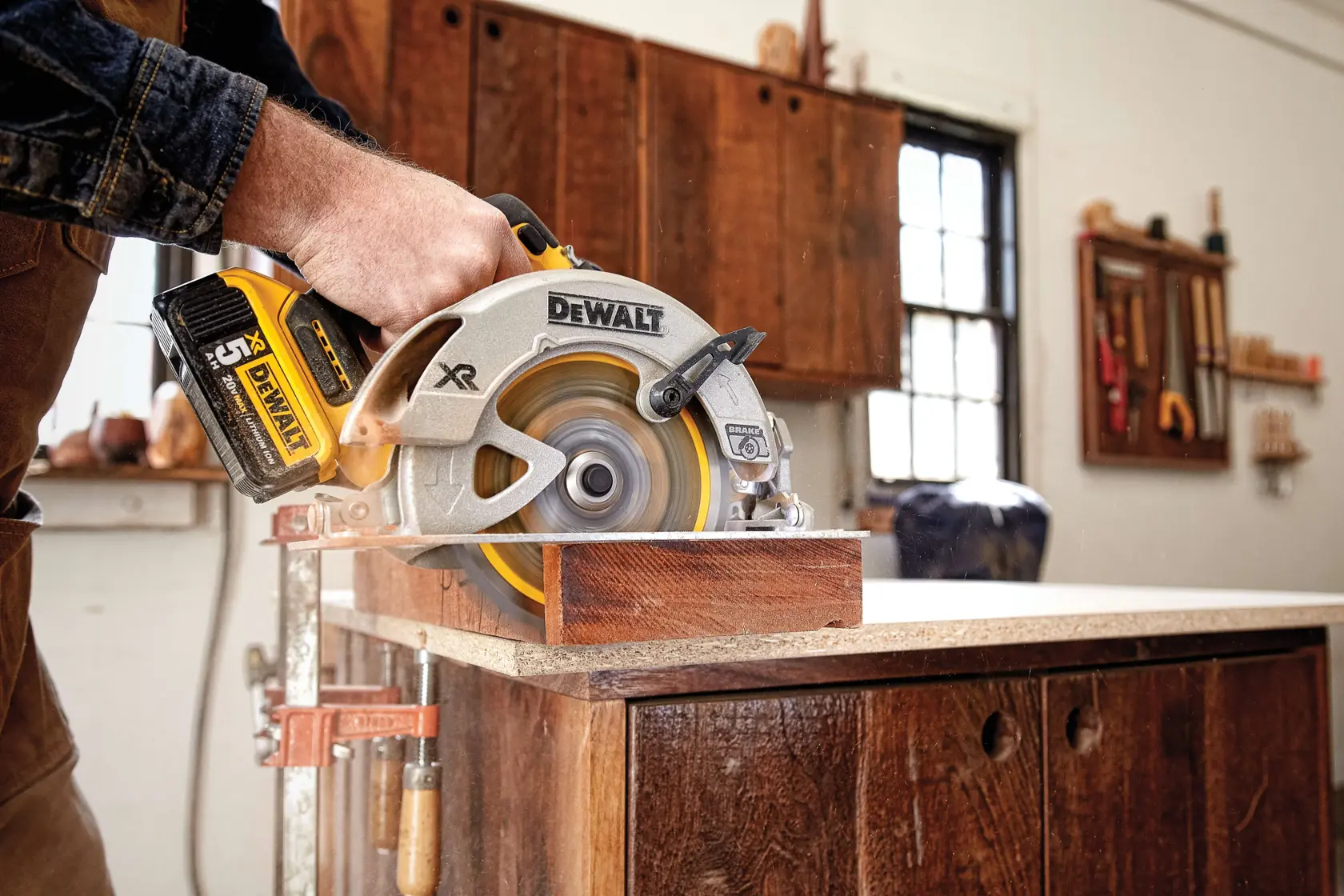 Sierra circular inalámbrica DEWALT cortando madera sobre una mesa de trabajo.