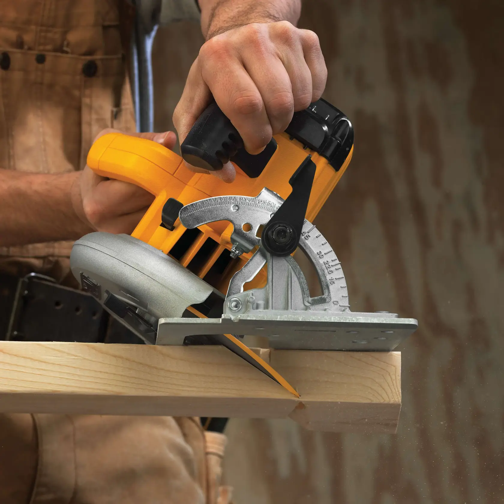 Primer plano de una persona usando una sierra circular amarilla DEWALT para cortar una tabla de madera.
